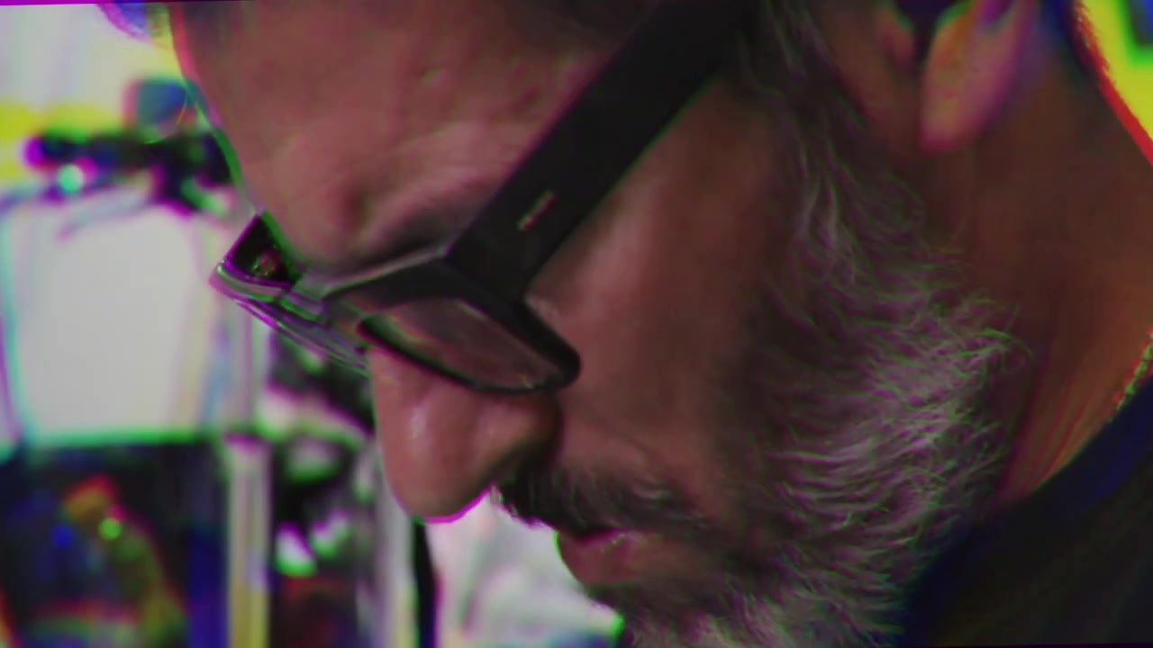 Bazooka Joe in profile, close up, bent over a drawing in the studio