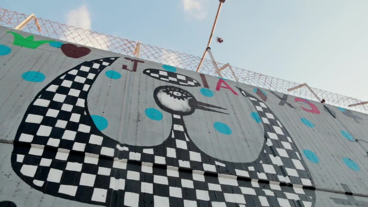 A checkered figure on the prison wall, seen from above, a still from Gangster of Art