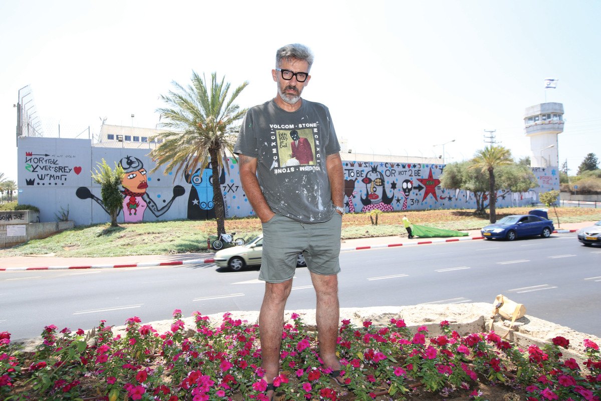 Bazooka Joe standing across the road from Walls of Hope, his mural on the prison wall